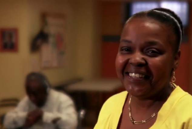Smiling nurse with dementia patient enjoying music