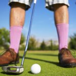 low angle photo of man playing golf taken at daytime
