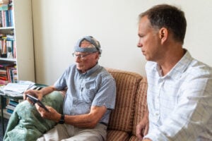 Doctor giving the Fastball Brainwave test to an elder man