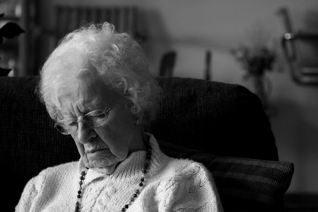 Elderly lady sleeping in chair during the day