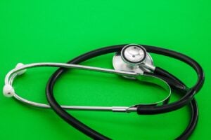 Stethoscope placed on a vibrant green background, symbolizing healthcare and medical practice.