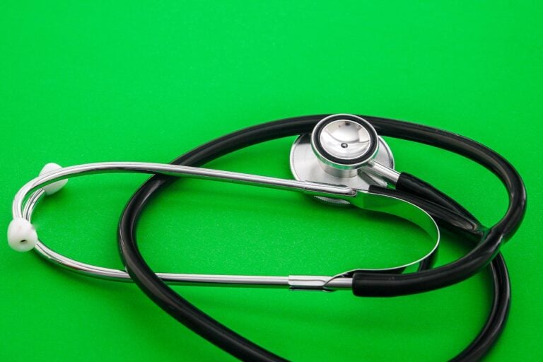 Stethoscope placed on a vibrant green background, symbolizing healthcare and medical practice.