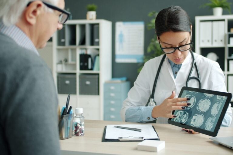 Doctor shows patient brain scans on tablet